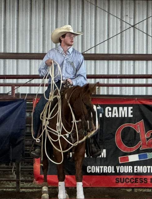 Roper coiling his rope on horseback in the arena at Lone Pine Ranch